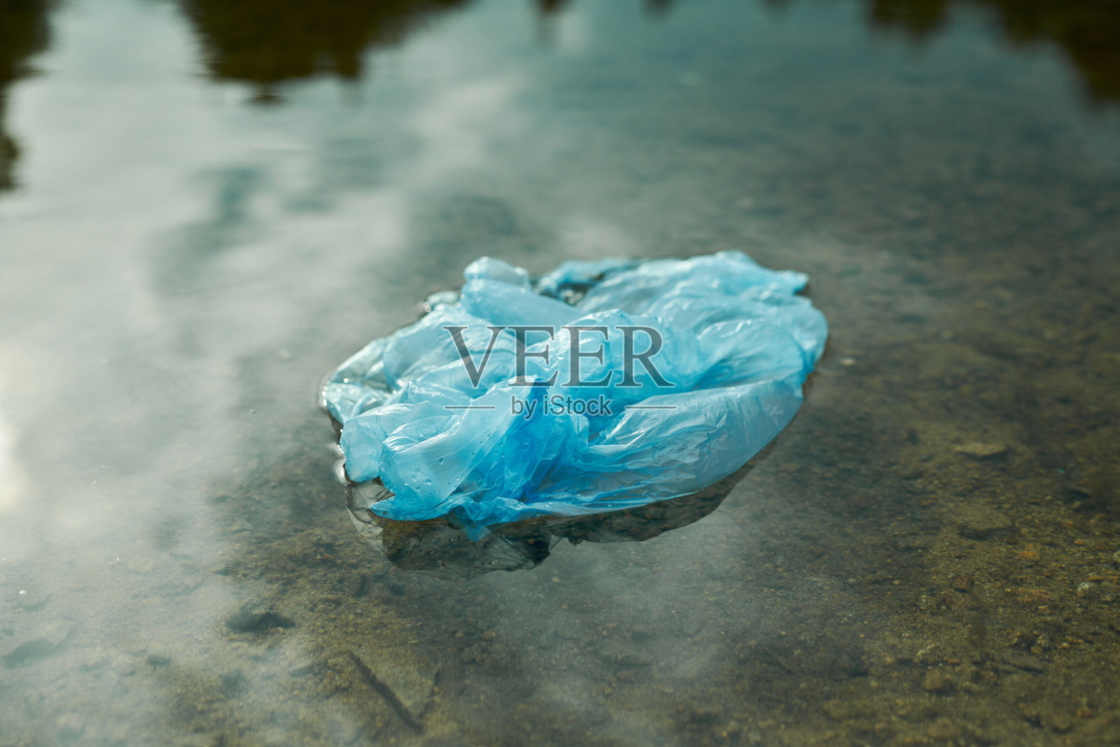 脏包躺在水里照片摄影图片