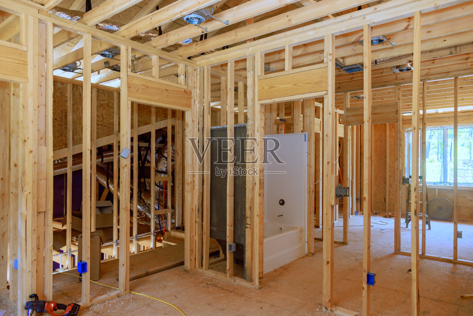 正在进行的浴室装修工程，将安装的管道与新安装的丙烯酸浴缸连接起来照片摄影图片