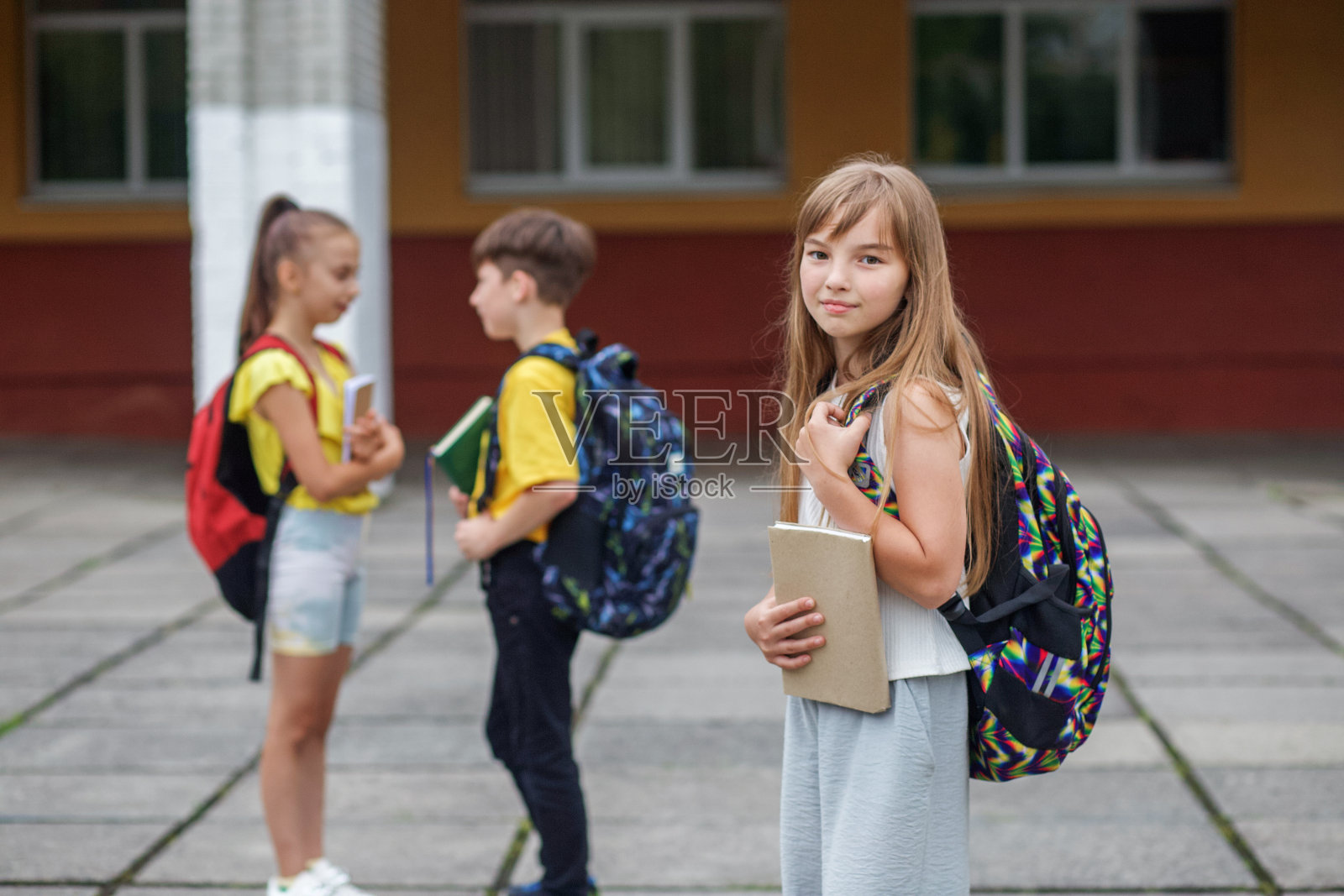在户外拿着书和背包的女学生。回到学校。开始上课。照片摄影图片