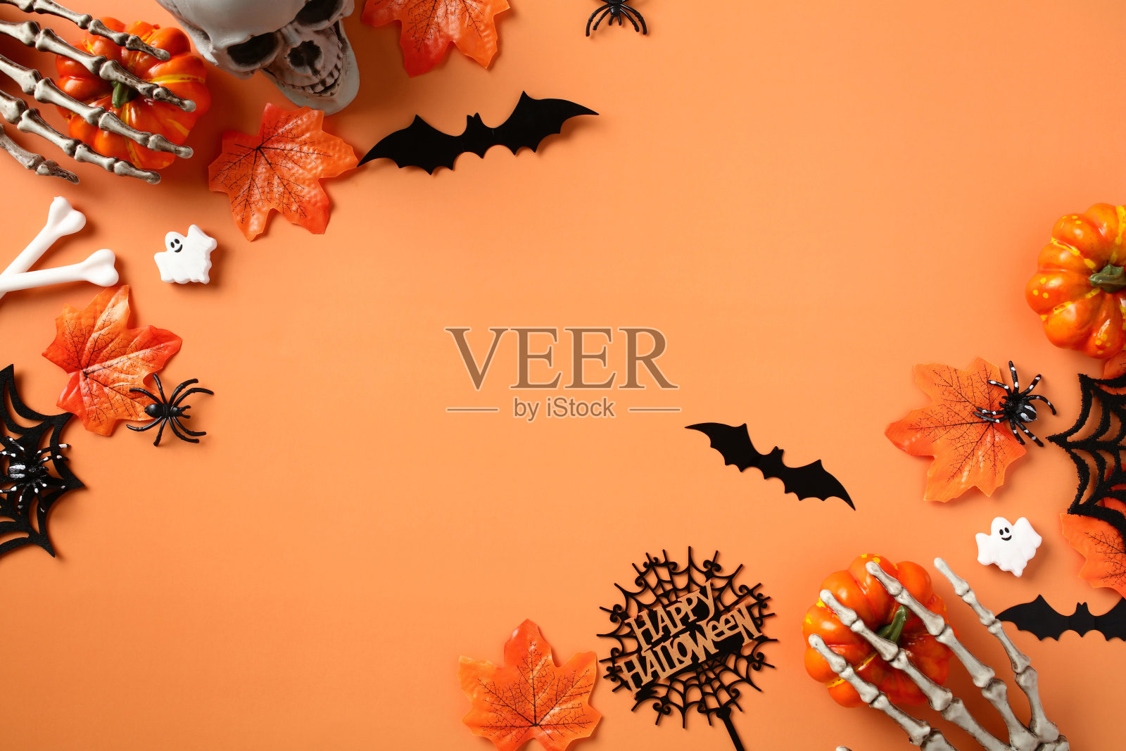 万圣节快乐节日贺卡模板。万圣节的装饰品，蜘蛛，南瓜，蝙蝠，鬼魂，橙色背景上的枫叶。照片摄影图片
