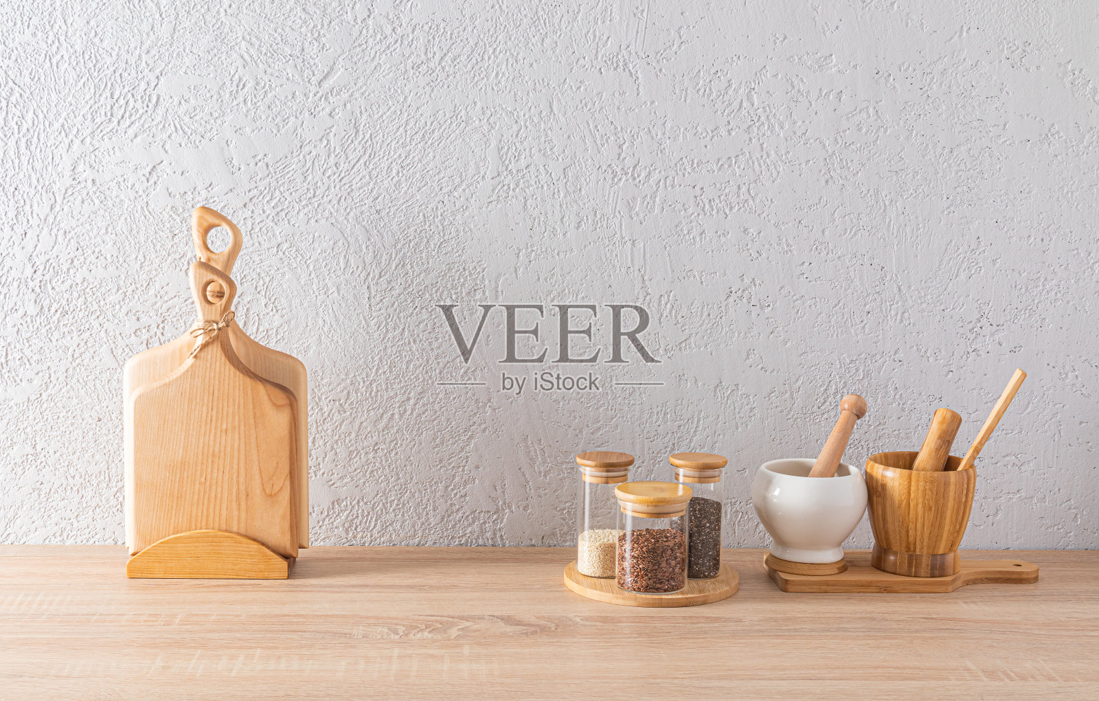 一套玻璃香料罐，两个带杵的臼，厨房台面上的切割木板。现代厨房内部的极简主义。照片摄影图片