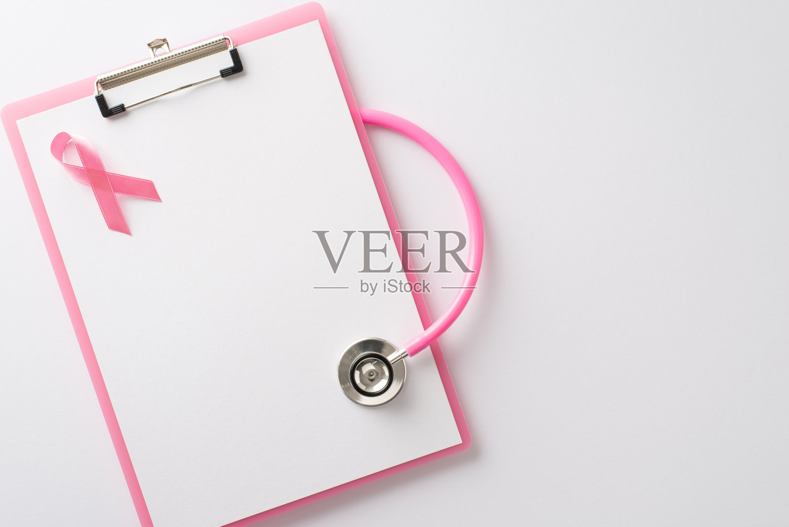 传播乳腺癌宣传月的信息。粉红色的剪贴板和粉红色的丝带在白色的孤立表面上的俯视图，copyspace适合文本或宣传材料照片摄影图片
