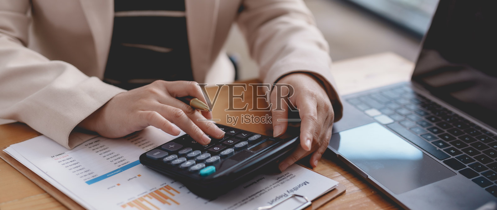 使用计算器从图表中查看公司的收入和预算。照片摄影图片