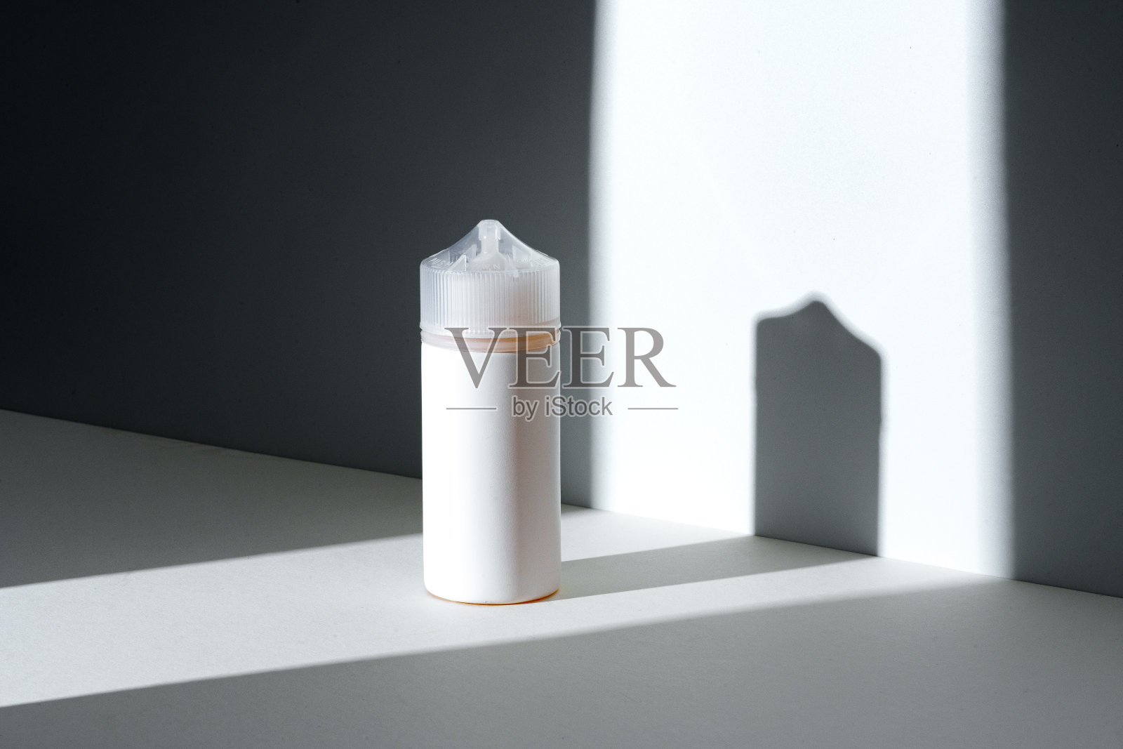 滴管瓶与vape液体在白色背景下的阳光与阴影照片摄影图片