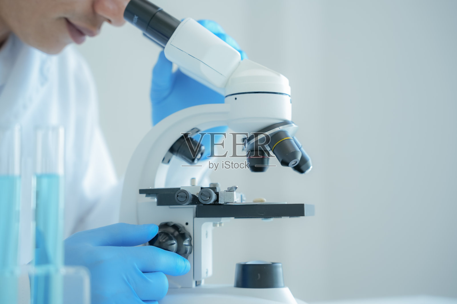 科学家在先进的科学实验室里分析生化样品。医学专业人员用显微镜观察病毒的微生物发育。实验室生物技术研究。照片摄影图片