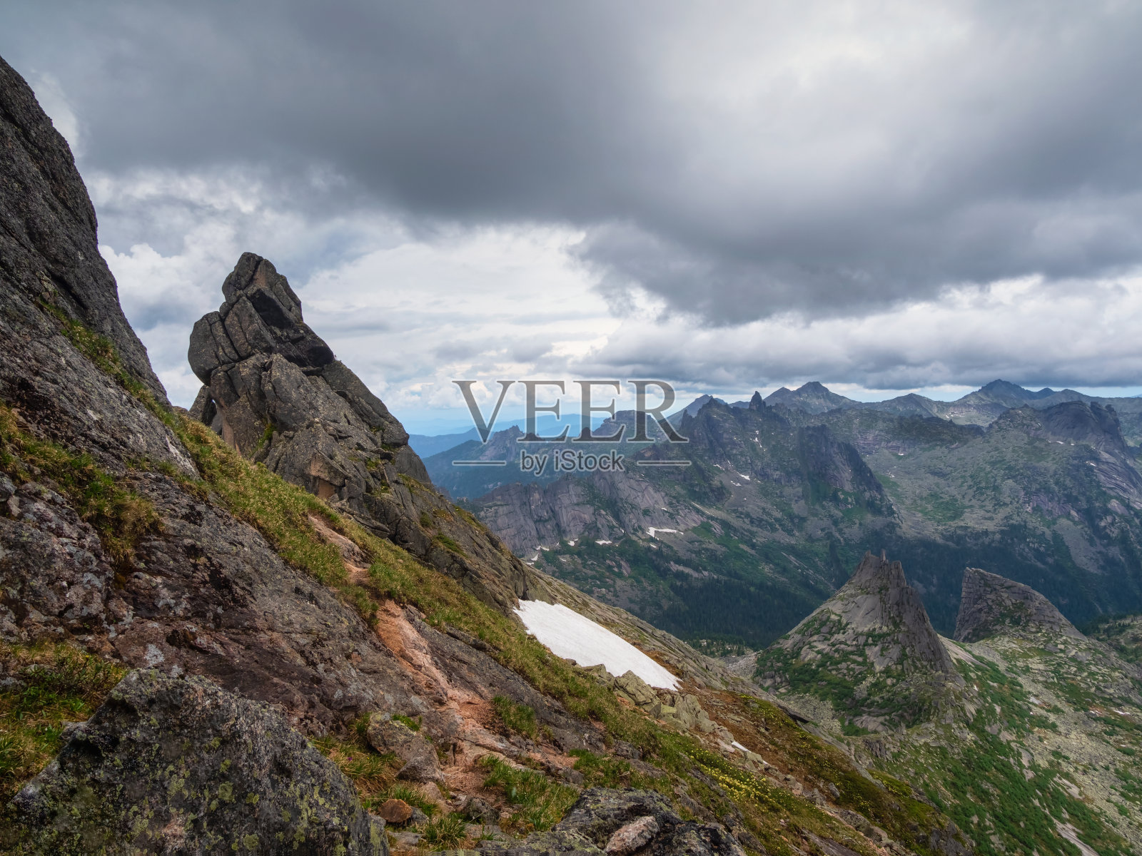 陡峭的悬崖山腰。鬼的岩石。雾蒙蒙的雨天的早晨，有大裂尖石的美丽山景。尖锐的岩石背景。照片摄影图片