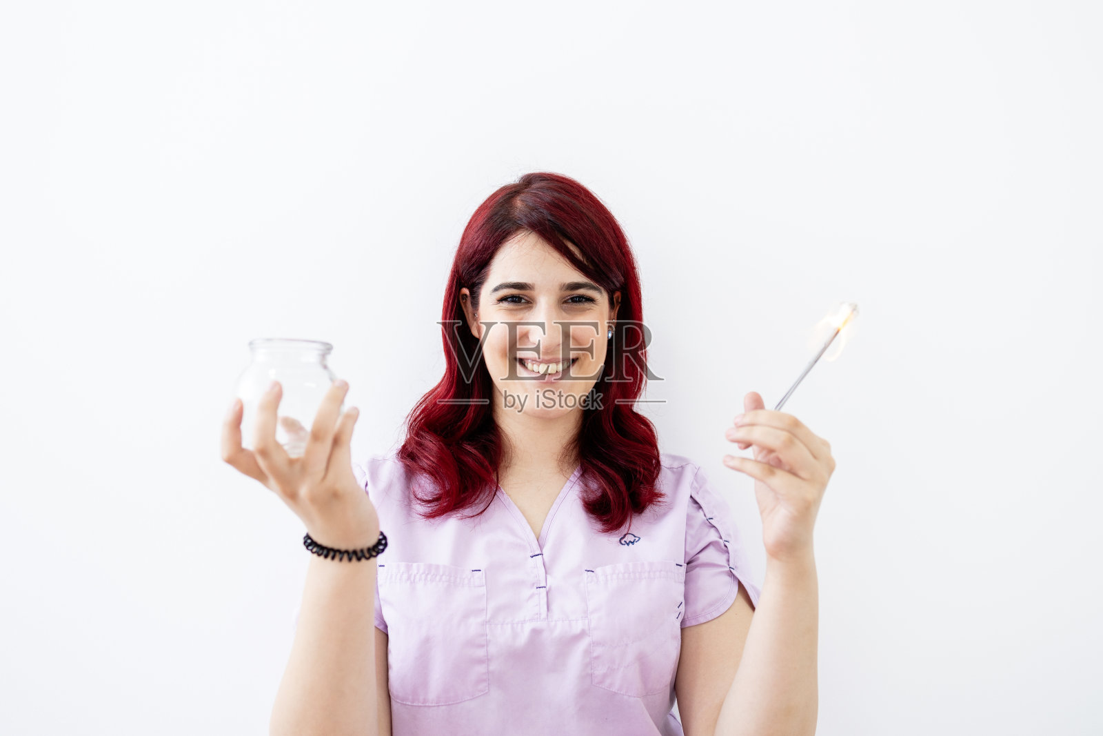 职业女性hijama治疗师在火罐治疗前手持真空杯和打火机的画像。照片摄影图片