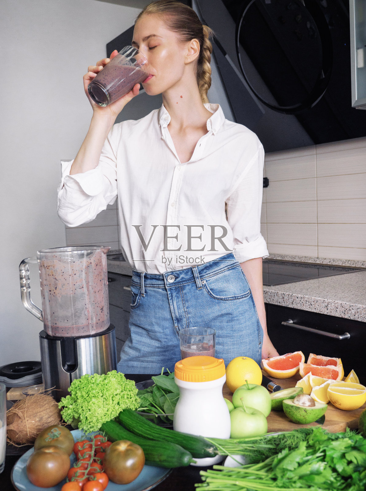 美丽的年轻女子正在用搅拌机准备健康的蛋白质奶昔照片摄影图片