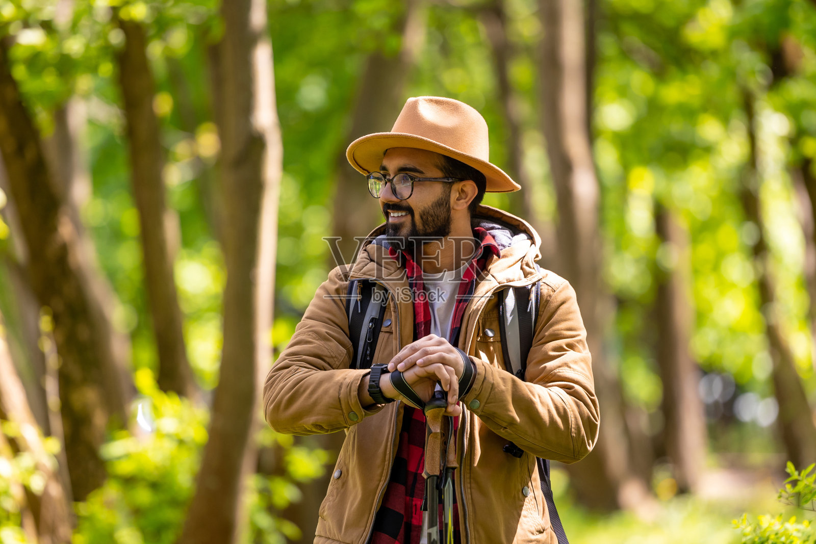 留着胡子的年轻人在森林里拿着斯堪的纳维亚木棍照片摄影图片