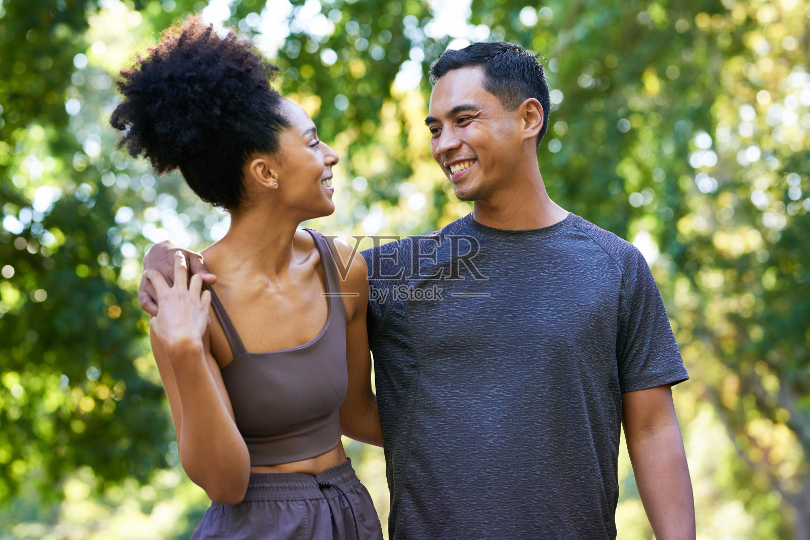 美丽的多民族年轻夫妇在公园里一起锻炼，摆姿势微笑照片摄影图片