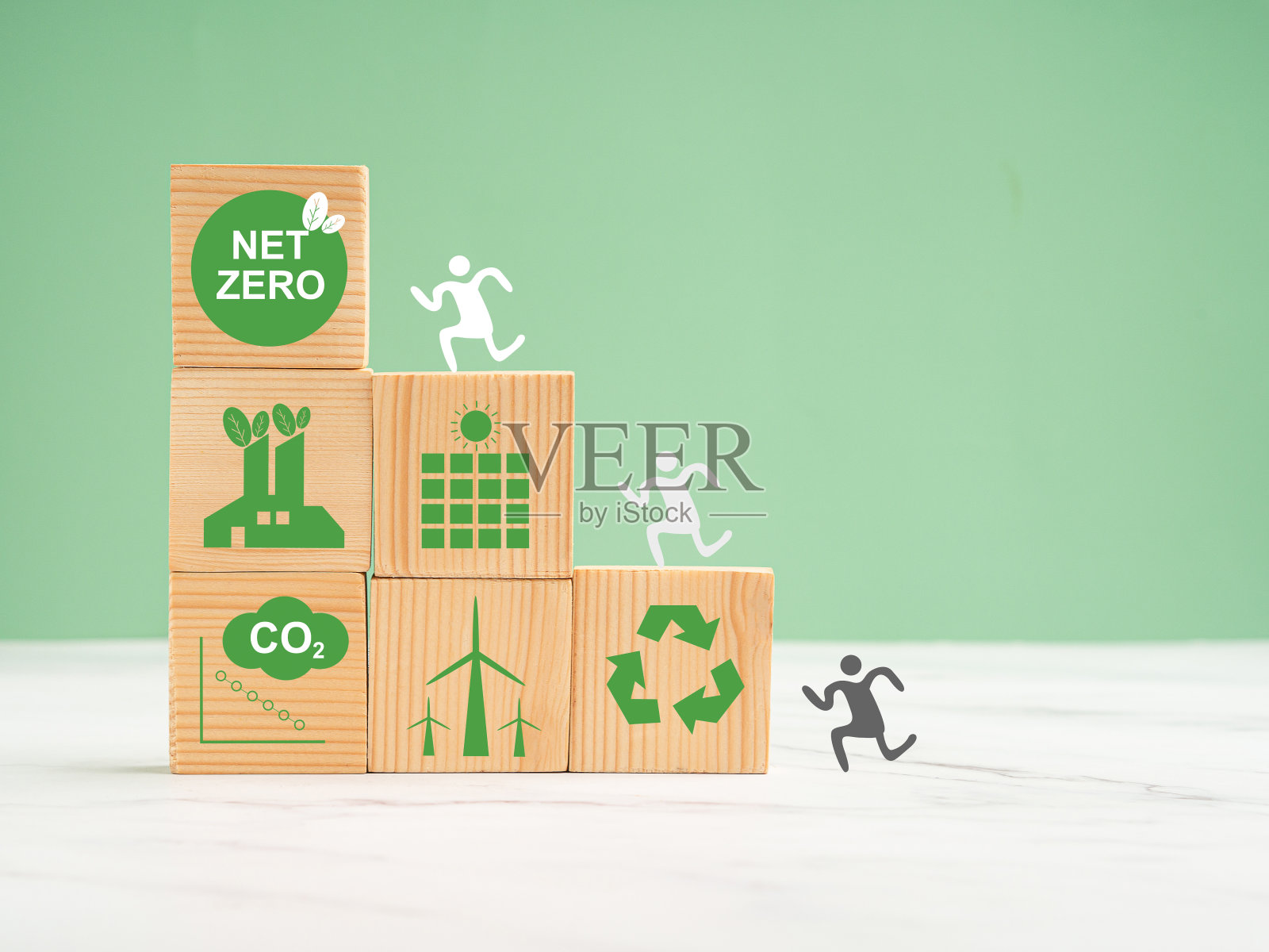 2050年实现净零排放。绿色背景下的大理石地板上有环保图标的木制立方体照片摄影图片