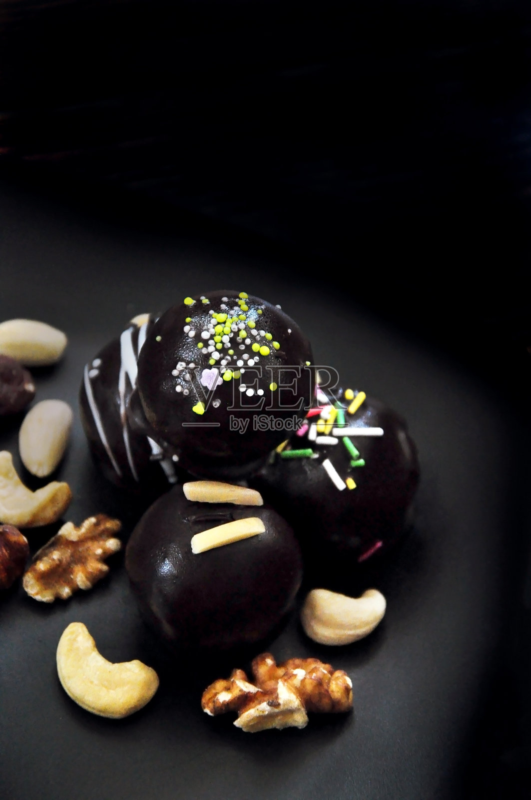 甜巧克力球与坚果黑色背景照片摄影图片