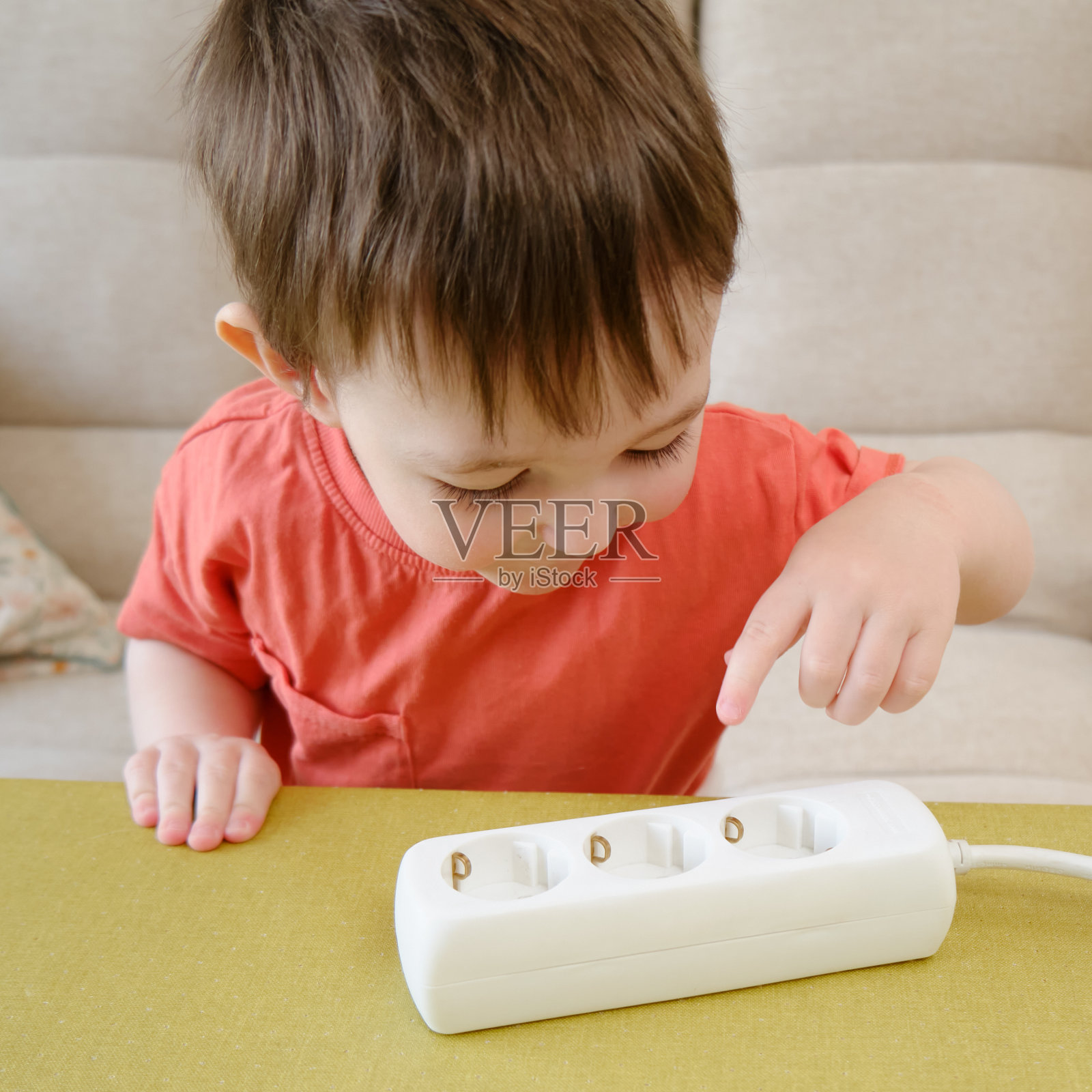 婴儿在家里玩电线是一种危险的活动，可能导致触电或受伤。两岁左右(一岁十个月)照片摄影图片