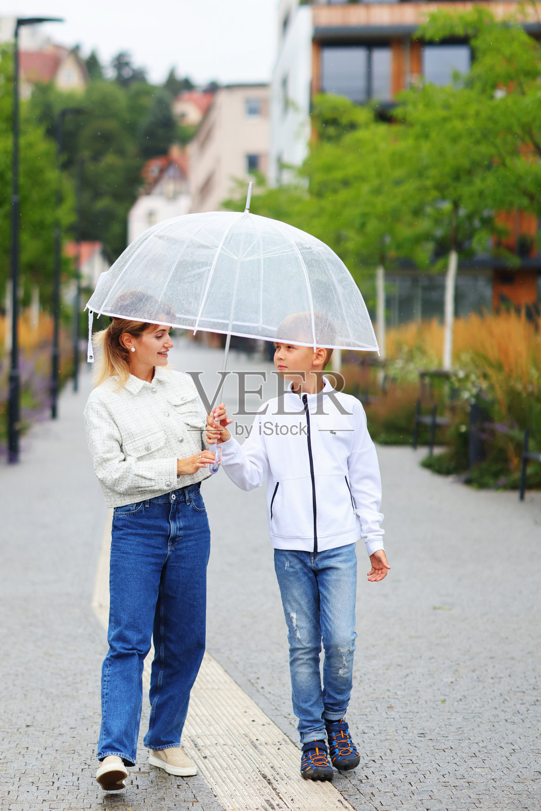 一对母子撑着雨伞在户外玩耍照片摄影图片