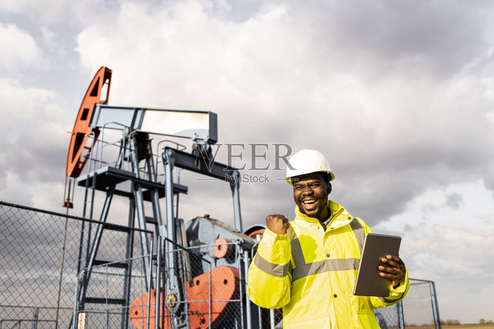油田工人庆祝原油采出效果好。照片摄影图片
