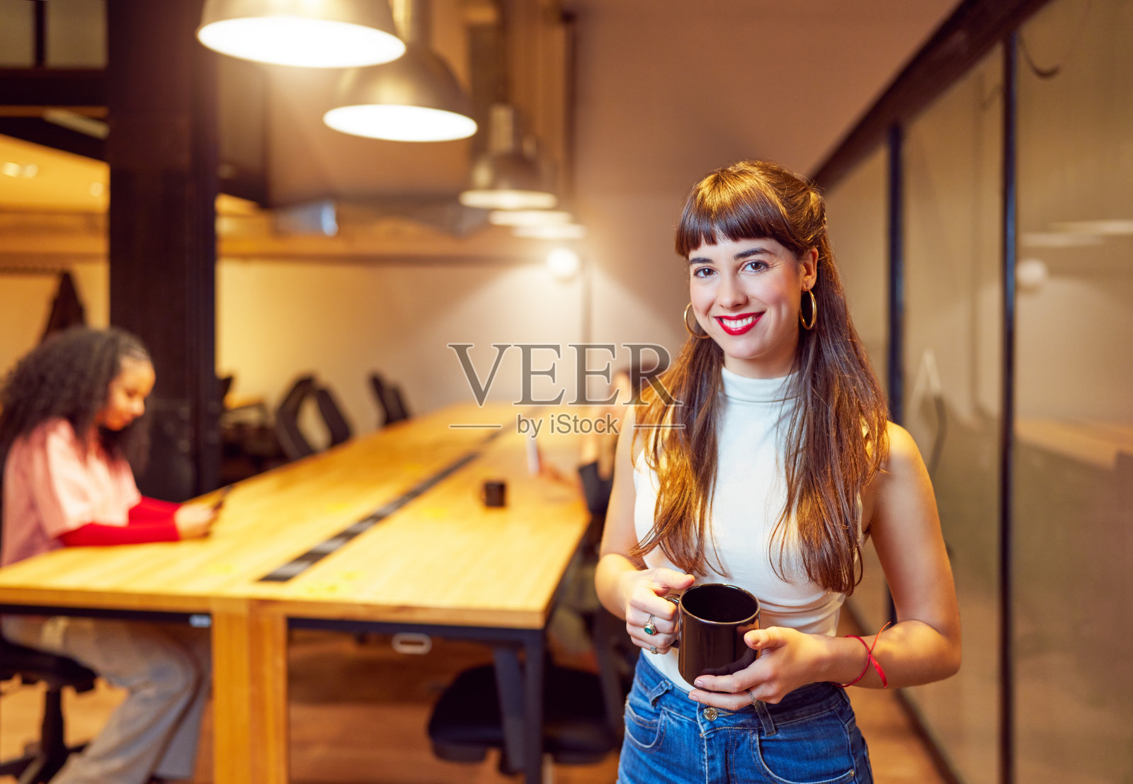 白人年轻成年女性在联合办公空间或大学内部微笑的肖像照片摄影图片