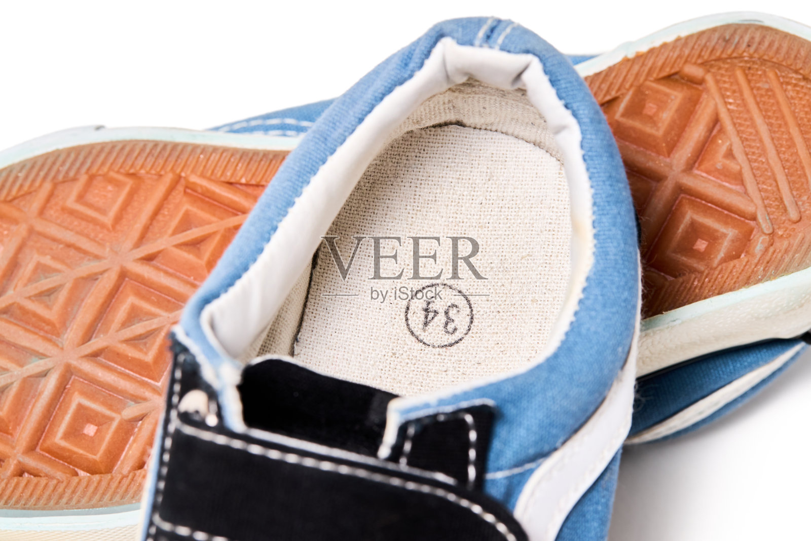 使用蓝色对婴儿运动鞋隔离在白色背景一个在另一个鞋底的一面与欧洲尺寸标准鞋垫尺寸号码。照片摄影图片