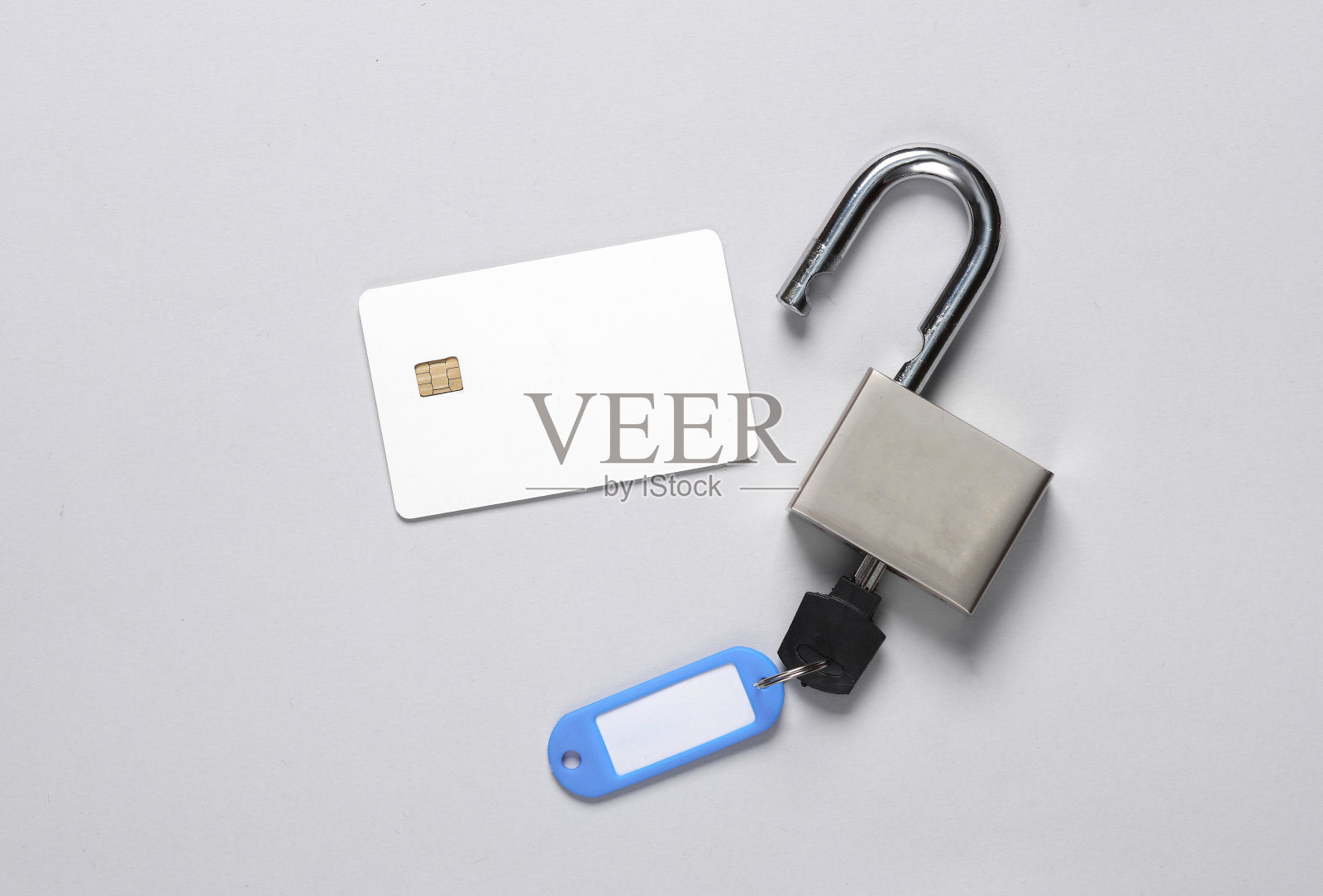 确保你的财务安全。灰色背景上带芯片和挂锁的白色空白银行卡照片摄影图片