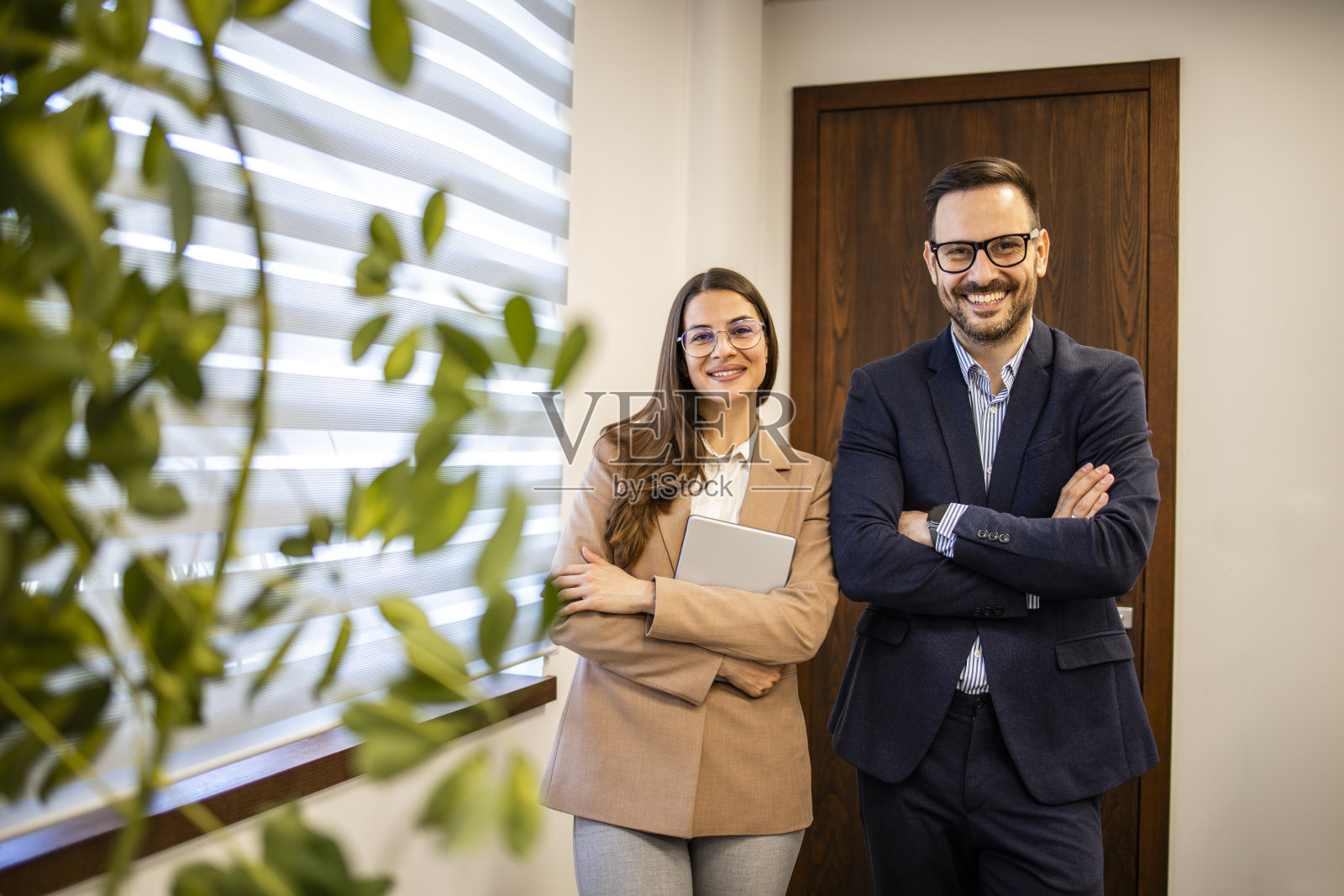 成功的商人微笑着站在办公室看着镜头的肖像。照片摄影图片