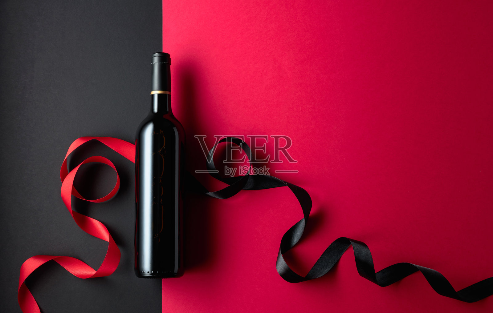 一瓶带缎带的红酒。照片摄影图片