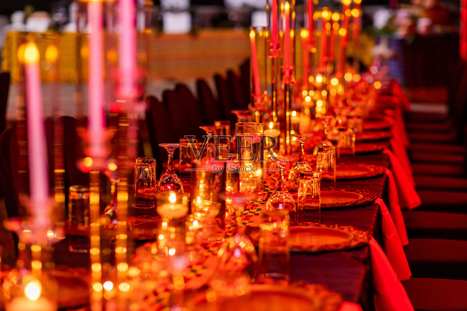 红色和金色主题烛光晚餐设置与酒杯，餐巾纸和盘子。照片摄影图片