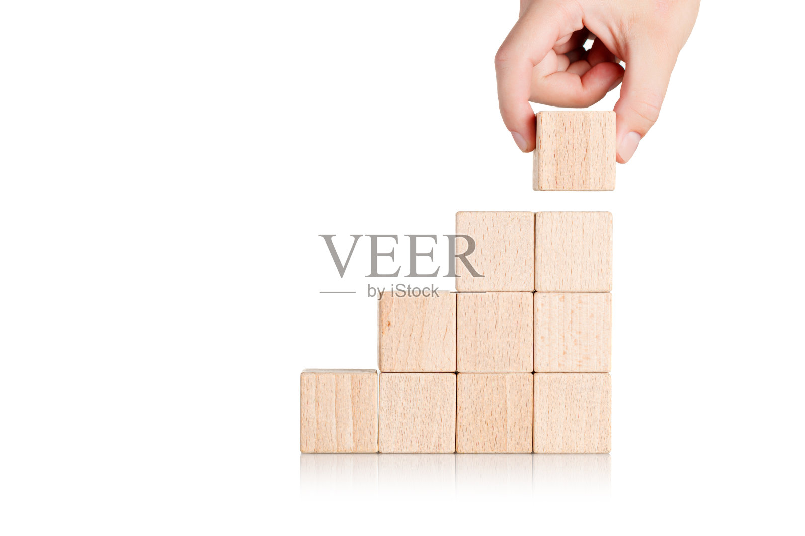 在一个孤立的白色背景上，有一只手的梯子形状的木制立方体照片摄影图片