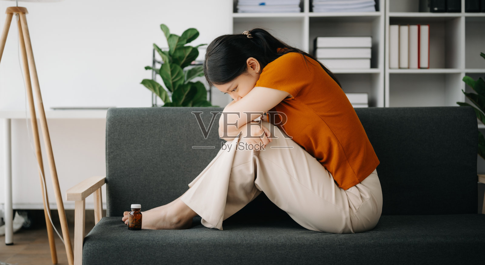 亚洲女性坐在窗边，眼神忧郁，感到焦虑照片摄影图片