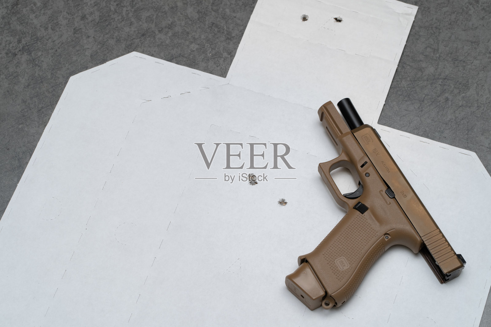 沙色手枪上的射击目标上有一个弹孔照片摄影图片