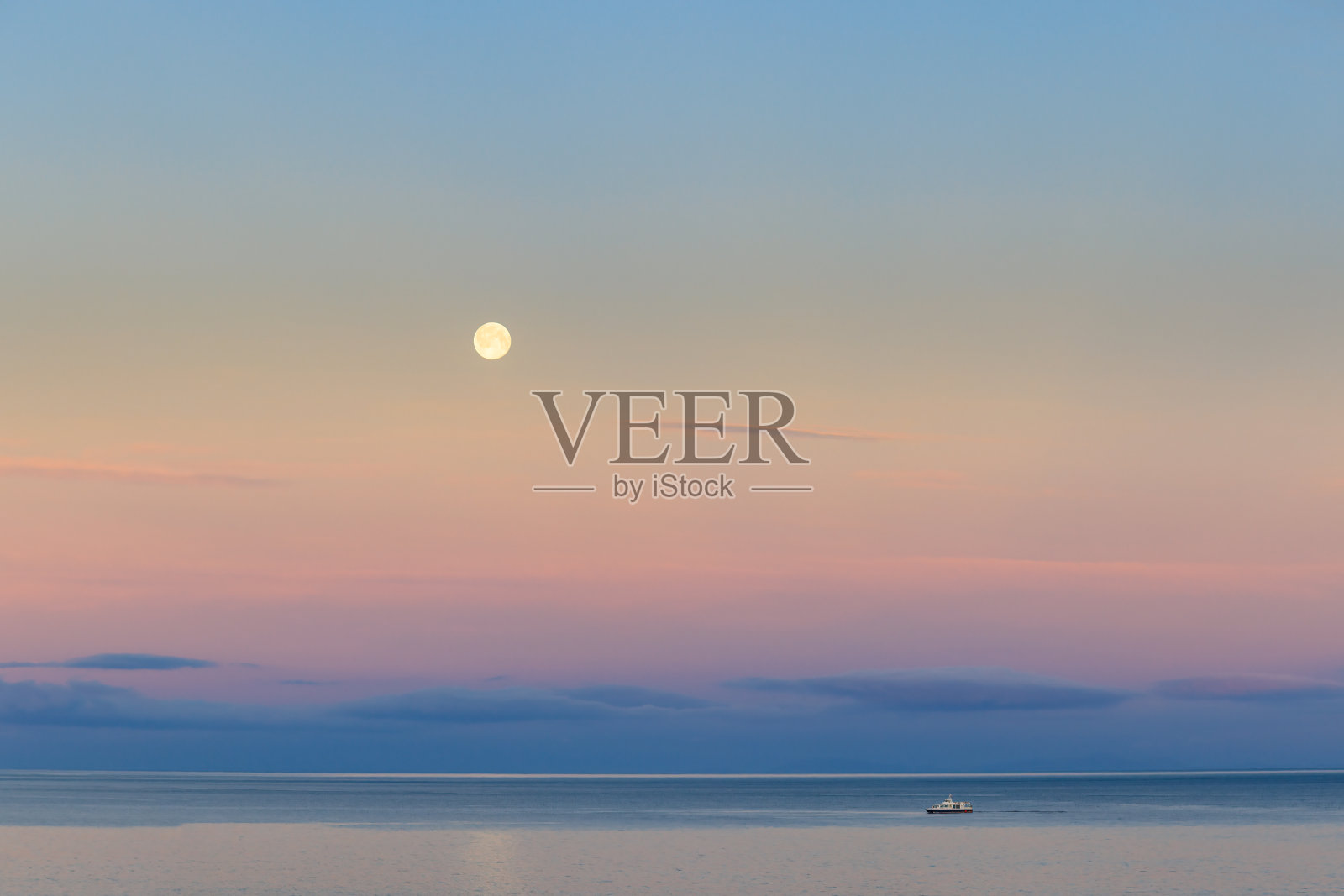 一艘帆船停泊在雄伟的苏格兰海湾，在美丽的蓝天白云下，平静的碧水和山峰在背景中照片摄影图片