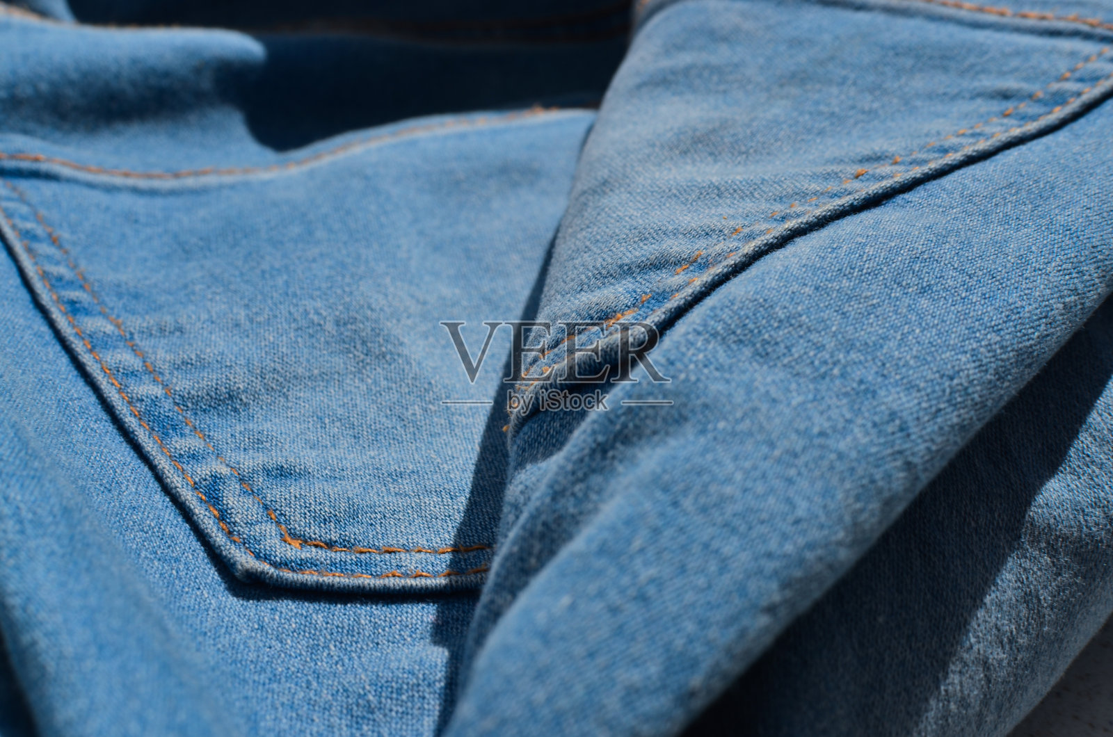 一条牛仔裤的缝纫线特写，展示了制造过程中的细心和技巧。非常适合时尚和风格相关的项目。照片摄影图片