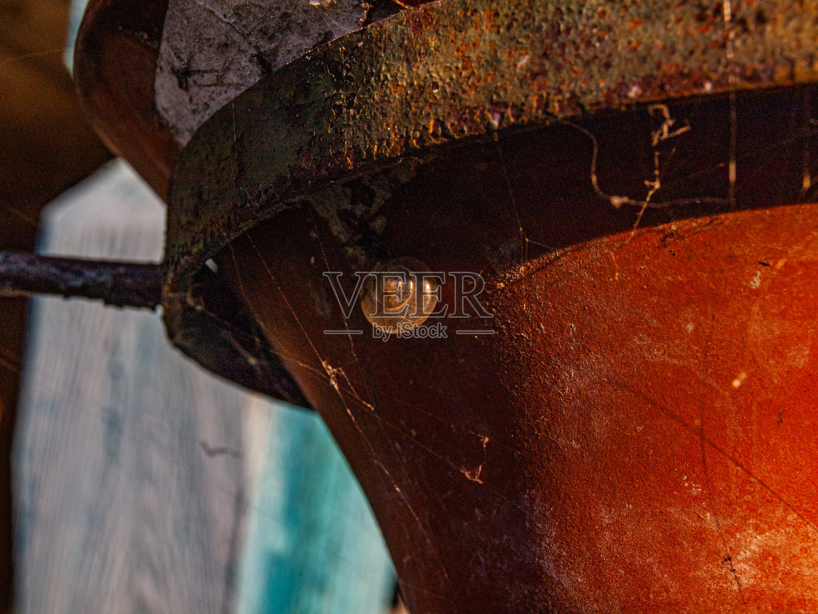 一个古老的砖红色花盆在阳光下悬挂着，一只蜗牛永远睡着了照片摄影图片