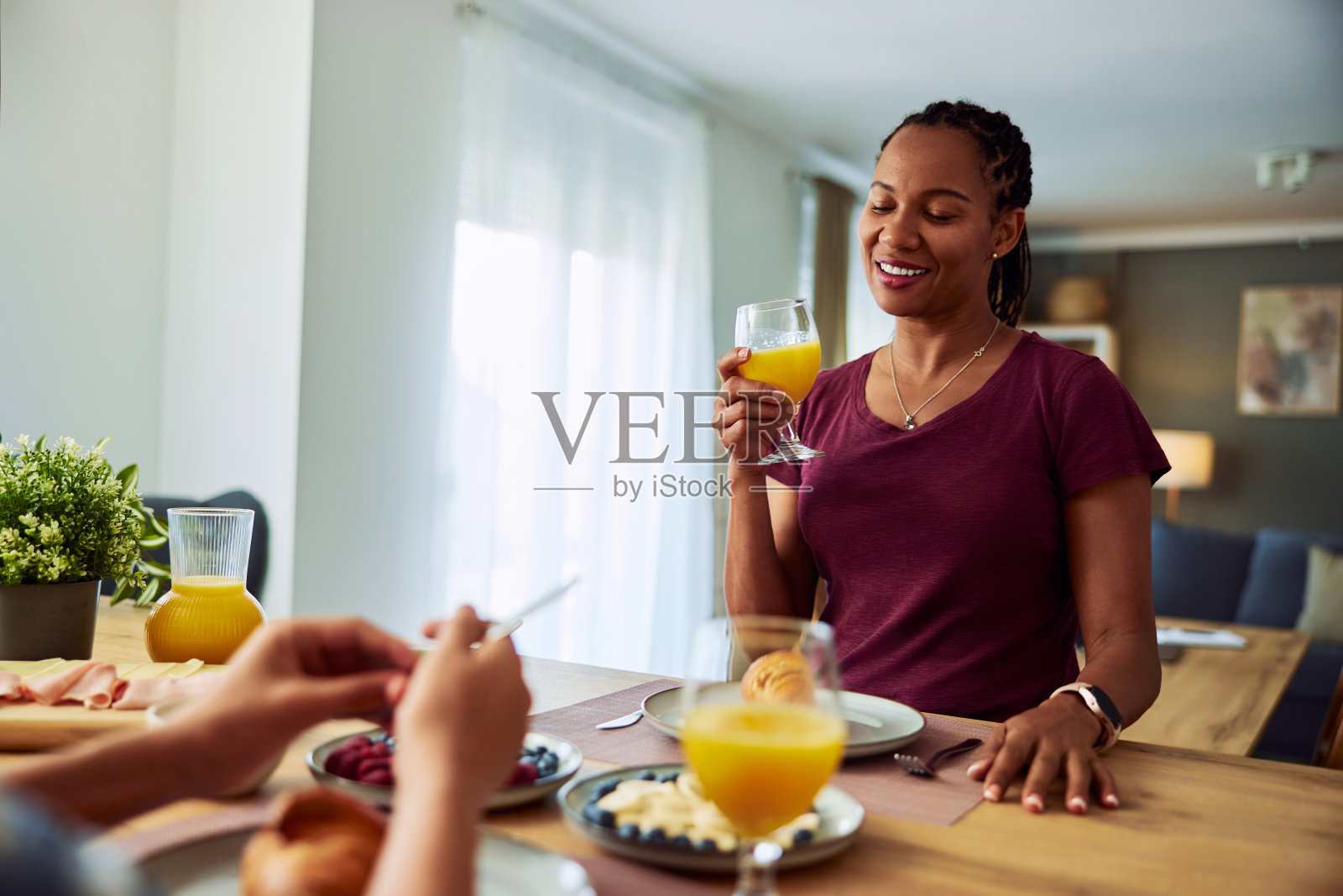 微笑的非裔美国妇女在家里享用美味的早餐。照片摄影图片