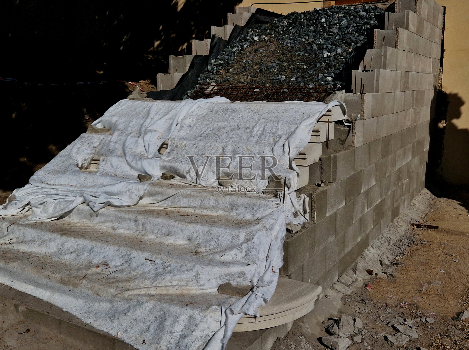 楼梯在混凝土基础上施工，台阶均为石阶铺设。为了避免损坏，它们都用床单盖着。石工广告照片摄影图片