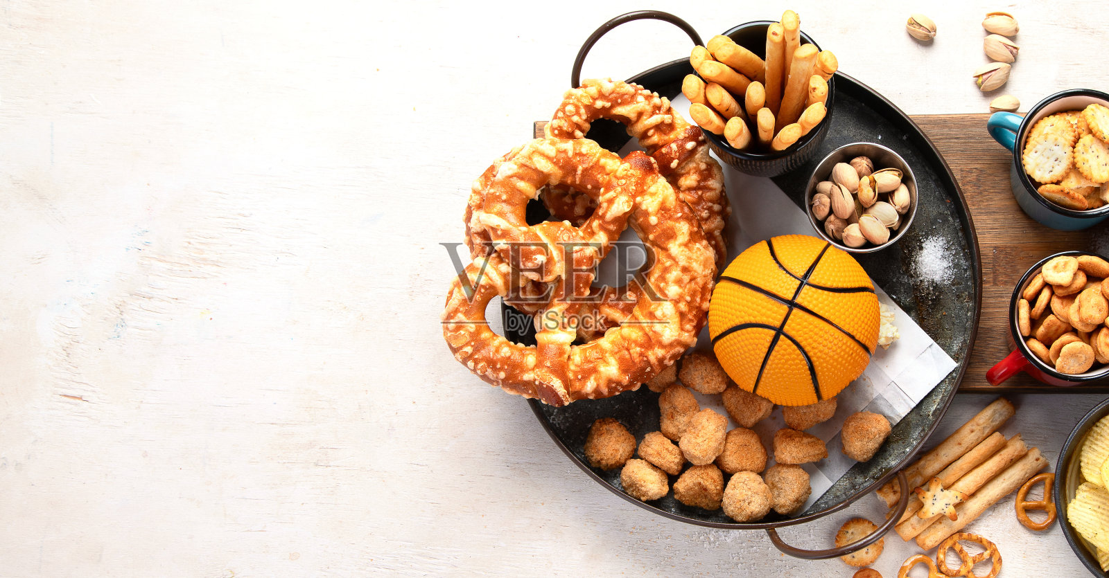 白色桌子上的小吃配上篮球，游戏之夜的食物。照片摄影图片