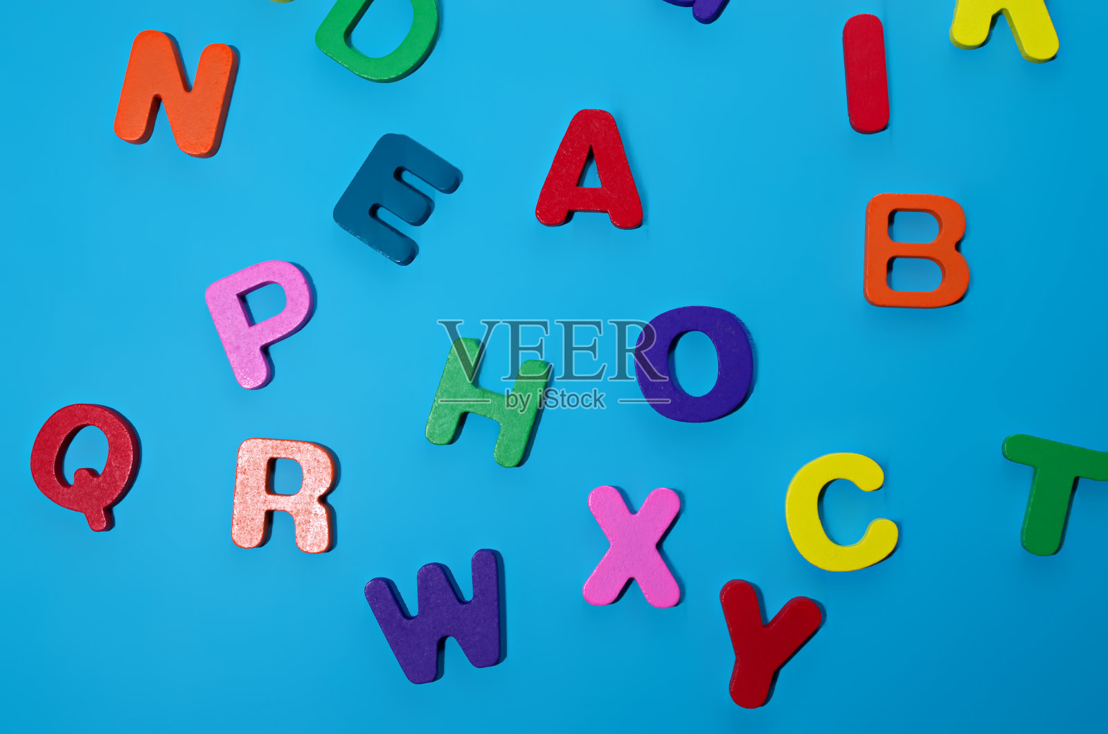 随机彩色字母木制集字母孤立在蓝色背景上回到学校的概念照片摄影图片