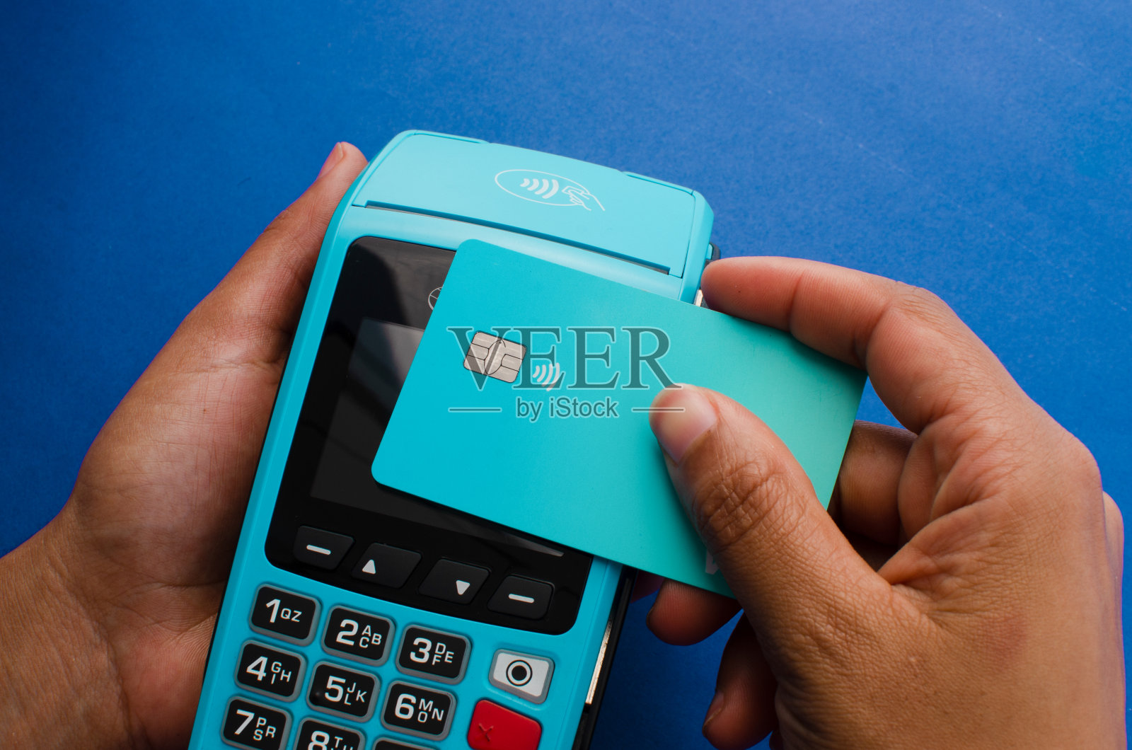 手持现代信用卡支付设备特写，非接触式技术方便快捷安全的交易。照片摄影图片