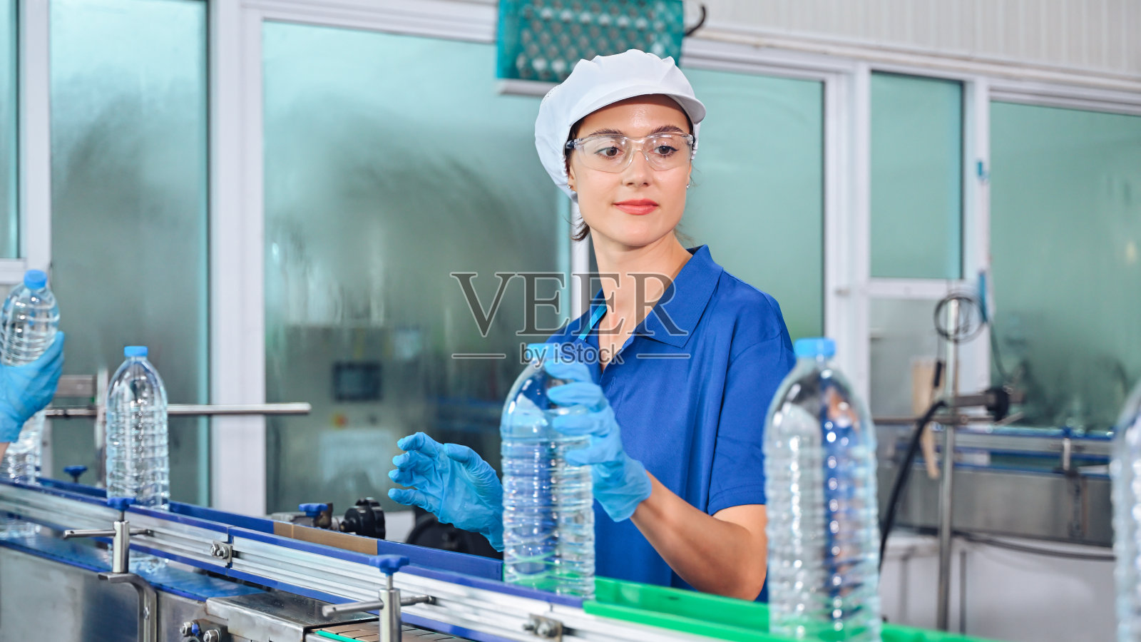 装瓶厂工人在装运前检查瓶装水的质量。用于工厂的反渗透系统。在装瓶过程中保持水的纯度和质量控制。高质量照片照片摄影图片