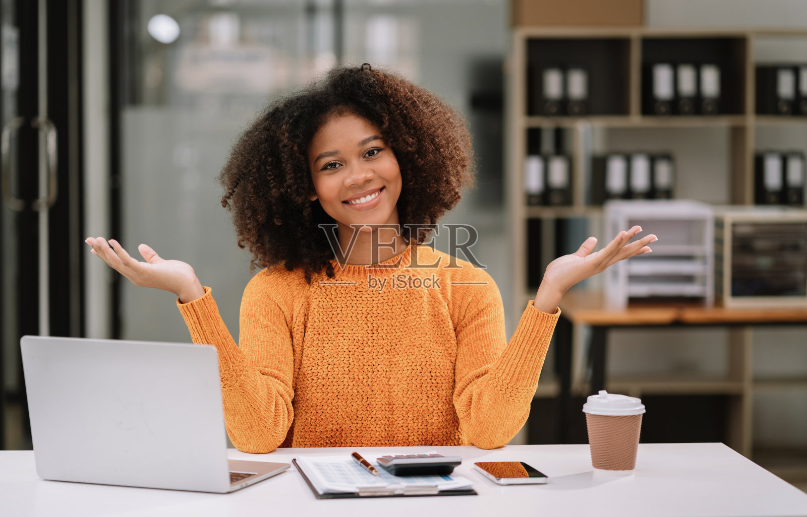 快乐的年轻女商人伸出或张开手掌，快乐地工作。照片摄影图片