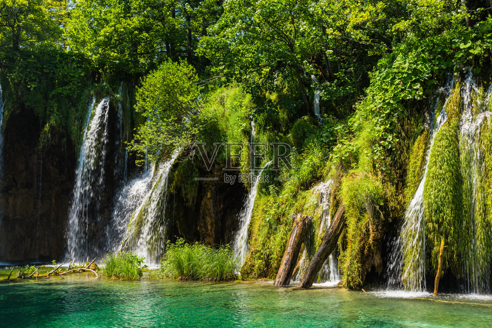 克罗地亚普利特维采湖国家公园里被绿色植物环绕的瀑布照片摄影图片