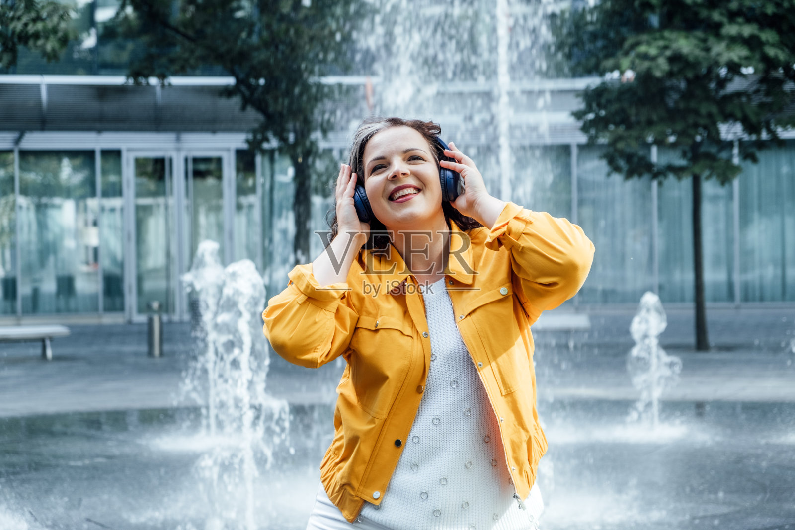 身心积极兼顾身心。练习冥想、瑜伽和自我护理来促进自爱和接受。戴耳机的女人的户外肖像照片摄影图片