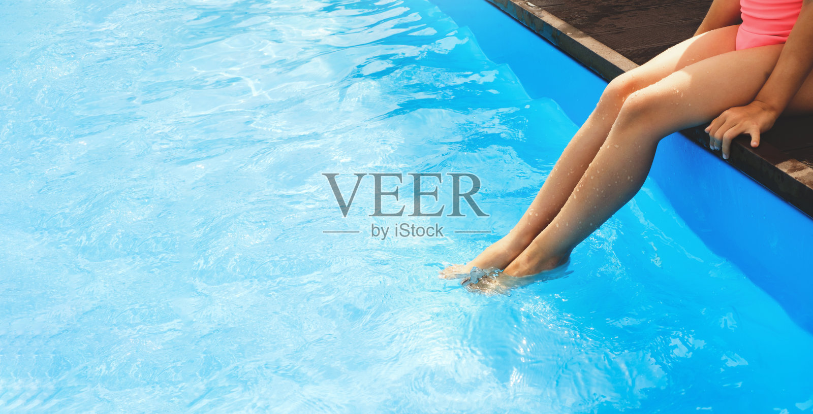 横幅。暑假或假日旅行。腿在游泳池里溅水照片摄影图片