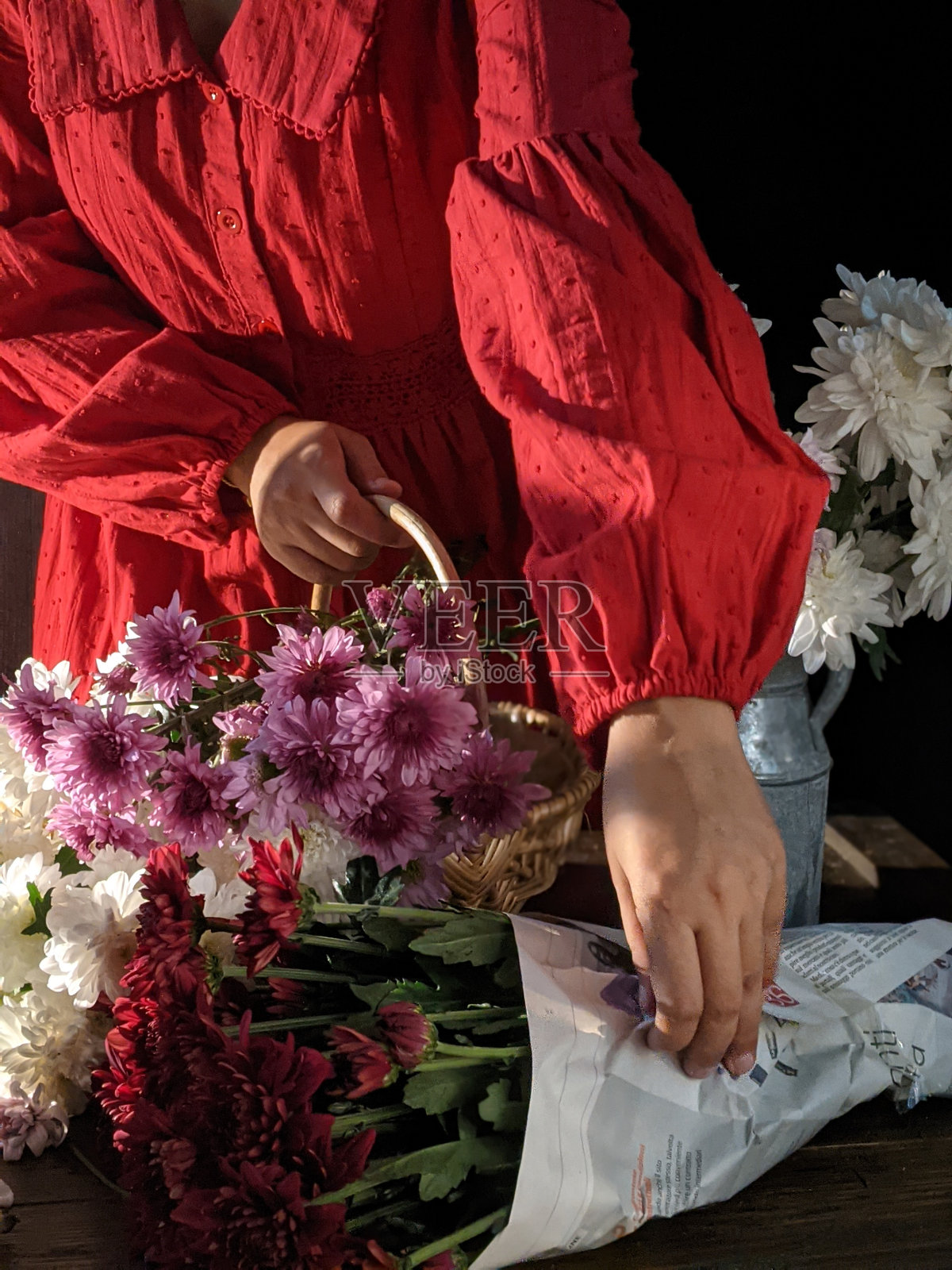 手里拿着一束白色背景的花。情人节礼物。献上一束花。女人节礼物。手持鲜花和蛋糕的妇女为母亲节和情人节的概念照片摄影图片