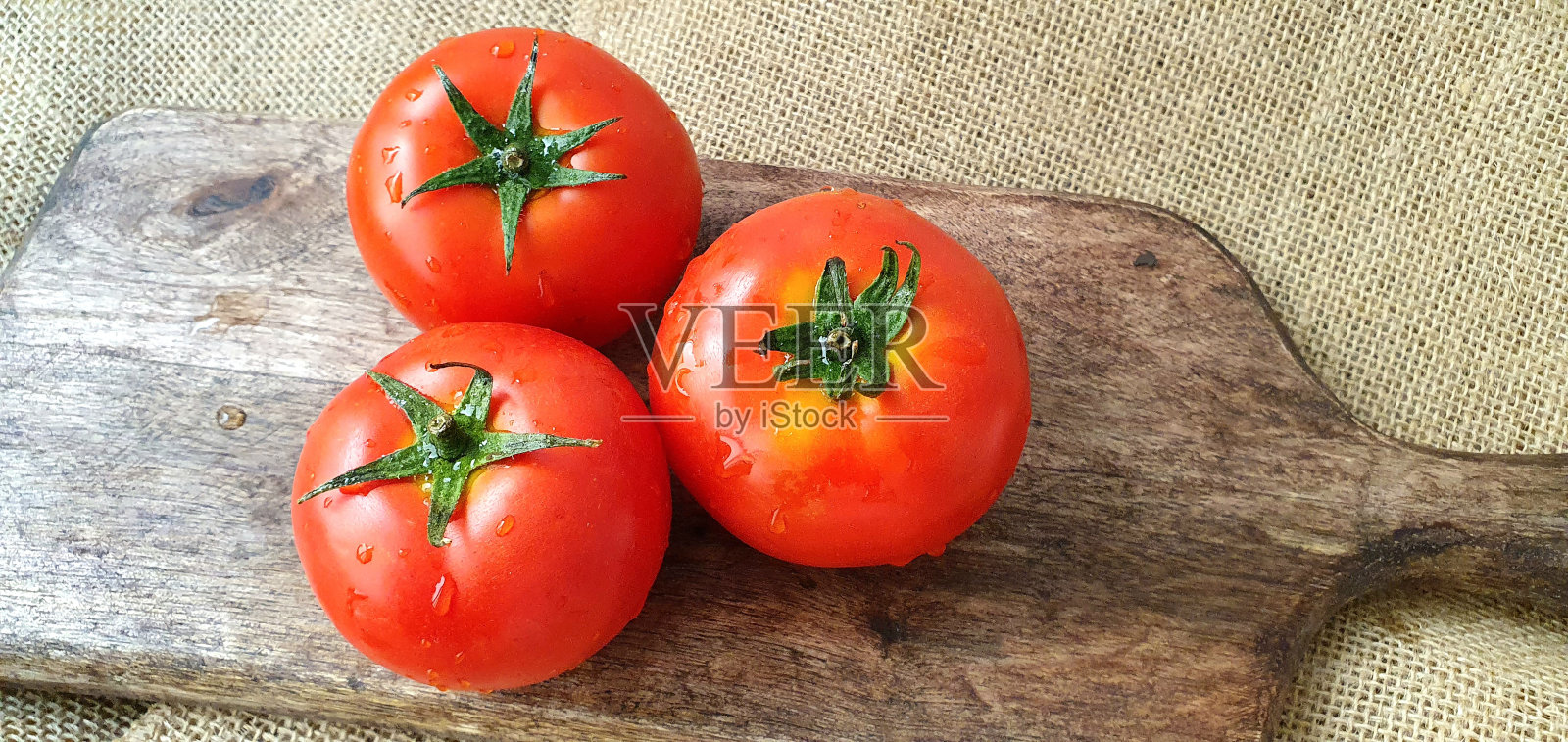 木板上熟透的西红柿特写。多汁的西红柿。桌子上的红西红柿。烹饪用的新鲜西红柿。照片摄影图片