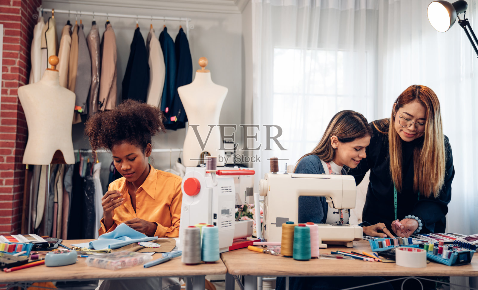 时尚的设计理念，年轻时尚的女性时尚设计师在工作室办公室工作。照片摄影图片