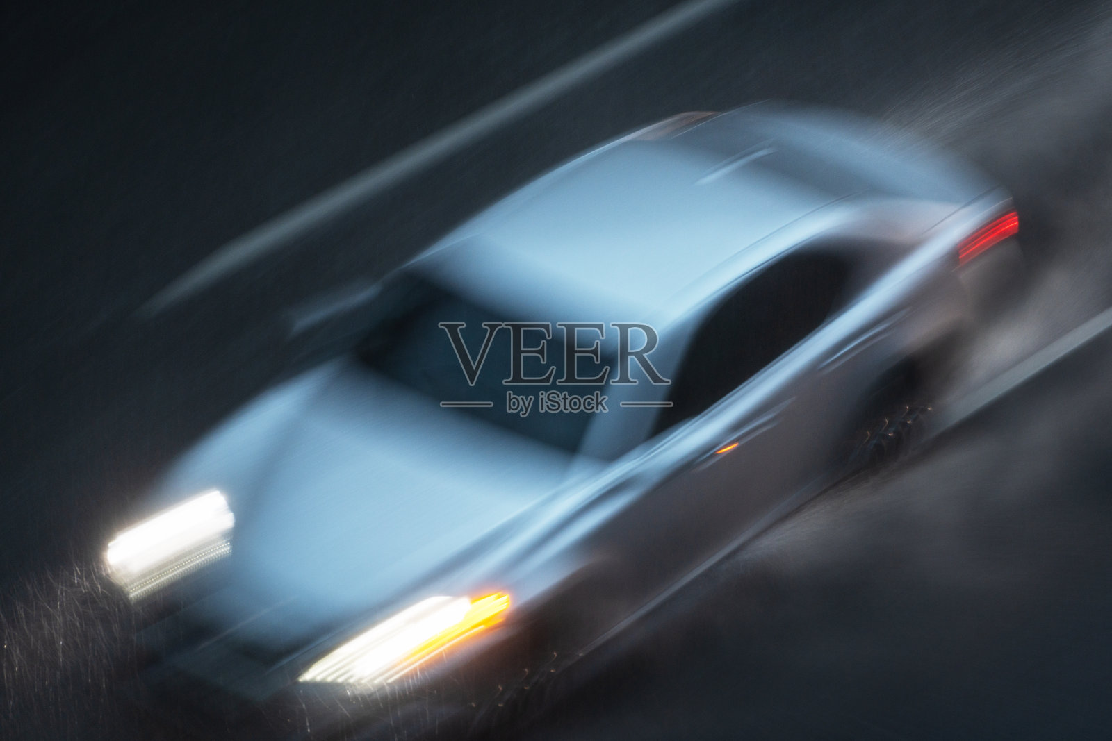 开着前灯的汽车在大雨中行驶照片摄影图片