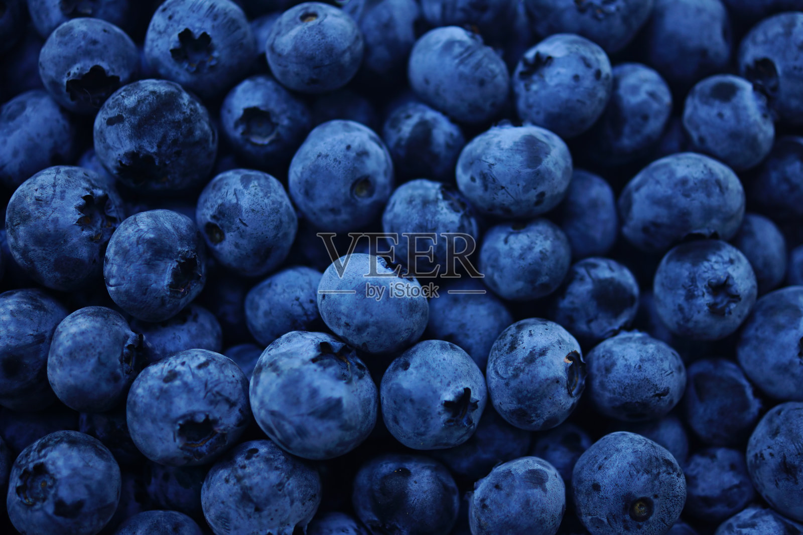 生蓝莓深蓝色的食物背景。照片摄影图片