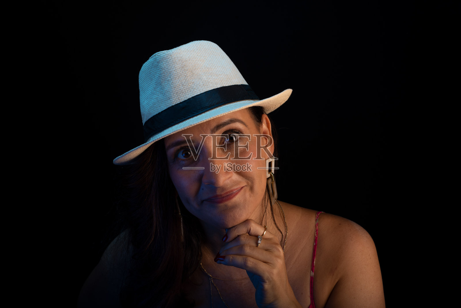 漂亮成熟的女人戴着帽子看着镜头。工作室肖像。照片摄影图片