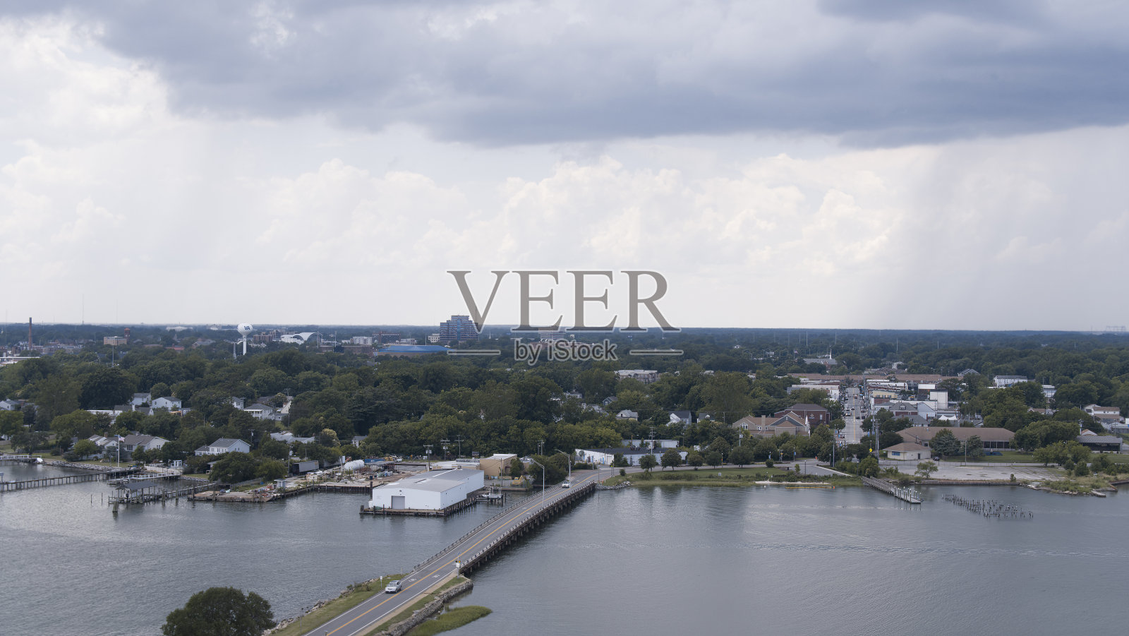 暴风雨的乌云笼罩着海滨社区。通向地平线的公路桥，汉普顿，弗吉尼亚州。鸟瞰图照片摄影图片