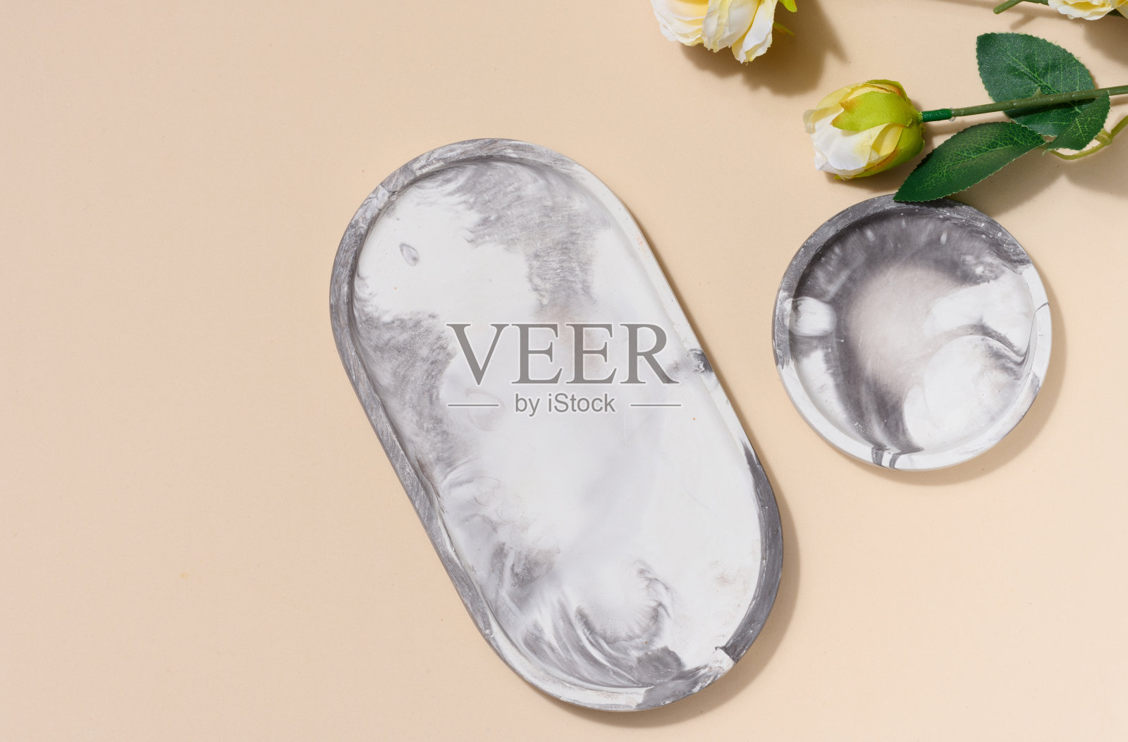 灰色的空装饰板和米色背景上的花朵，产品和化妆品展示舞台，俯视图照片摄影图片