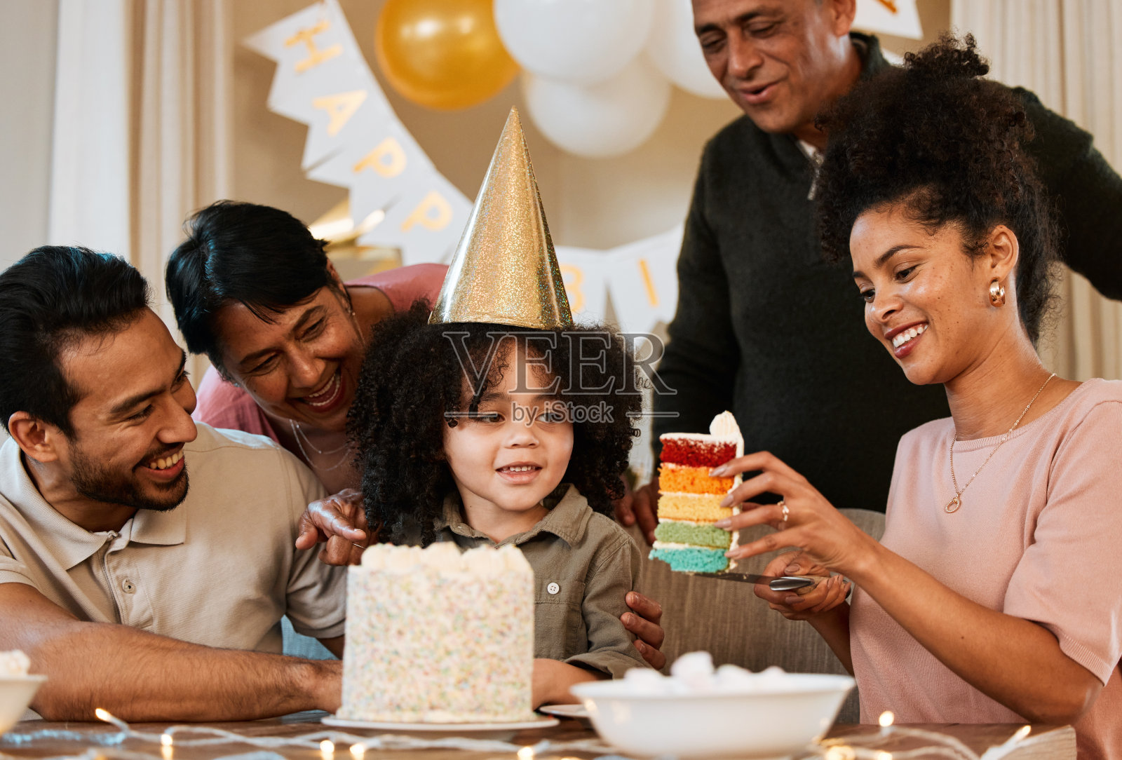 父亲，母亲和孩子与家人，生日蛋糕，和庆祝的聚会，关心和团结在家里。爸爸，妈妈，孩子和爷爷奶奶，兴奋的脸和爱一起在公寓活动照片摄影图片